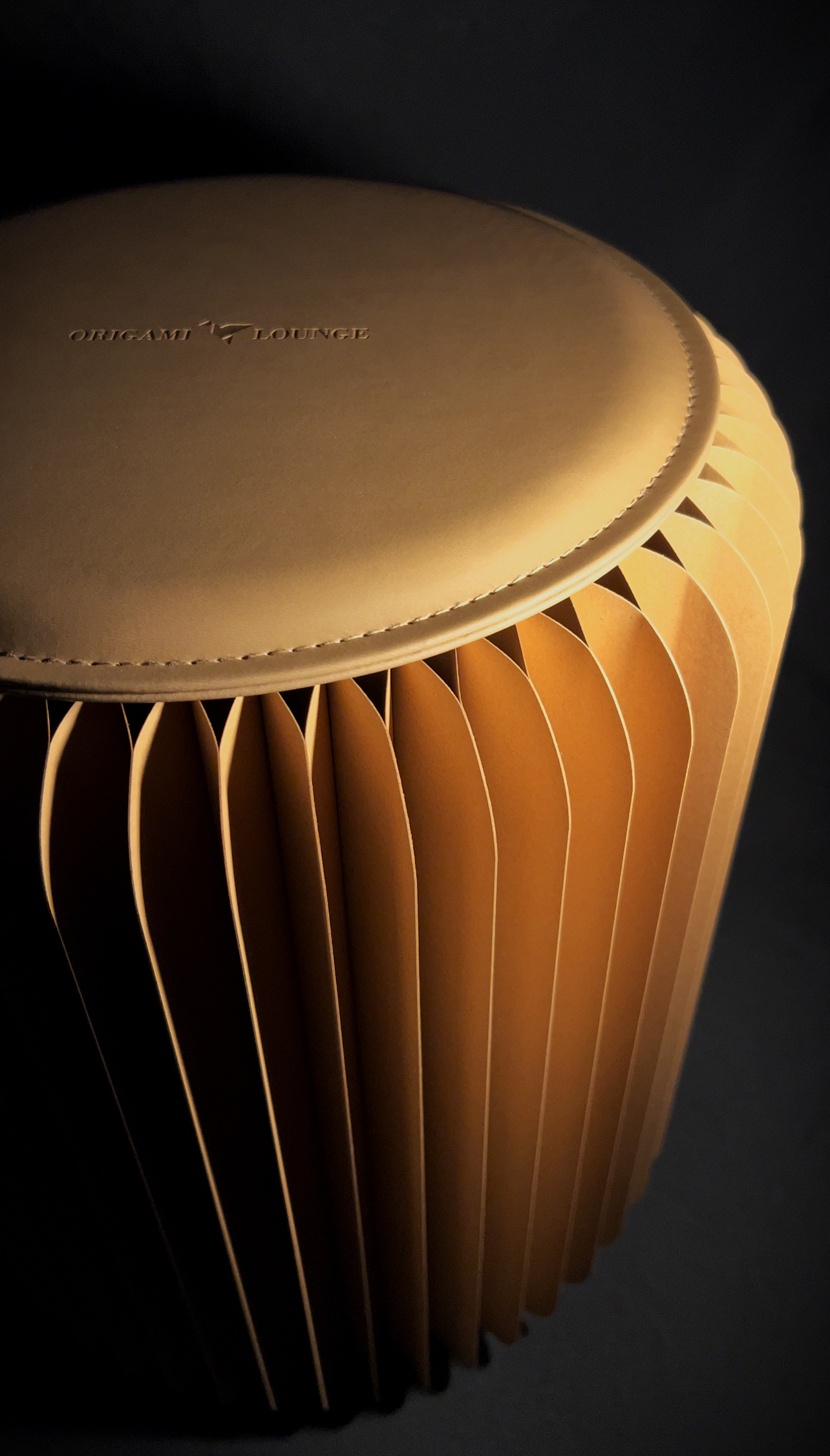 close up brown foldable stool with leather cushion honeycomb cardboard design